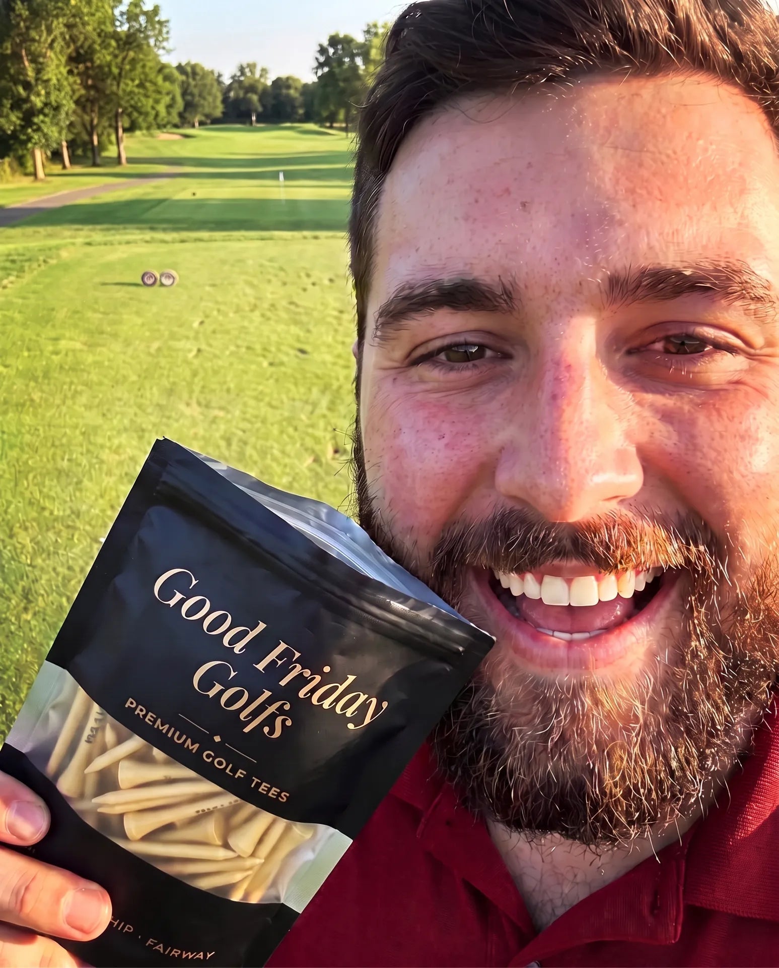 Golfer holding a pouch of Good Friday Golfs tees on the tee box at golden hour